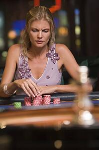 Woman in casino playing roulette and thinking (selective focus)