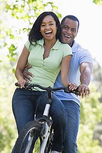 Couple on a bike outdoors smiling