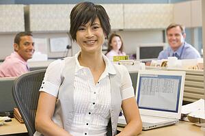 Businesswoman in cubicle smiling