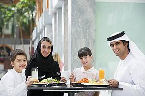 Family at restaurant eating and smiling (selective focus)