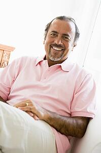 Man sitting in living room smiling (high key)