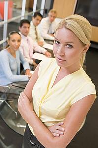 Businesswoman with four businesspeople at boardroom table in background