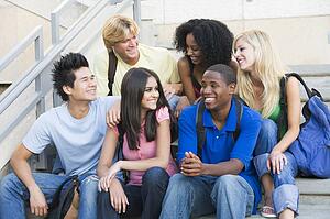 Six people sitting on staircase outdoors smiling
