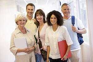 Five people standing in corridor with books (high key)