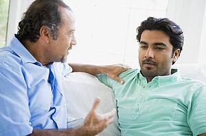 Two men in living room talking (high key)