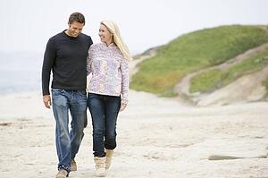 Couple walking at beach smiling