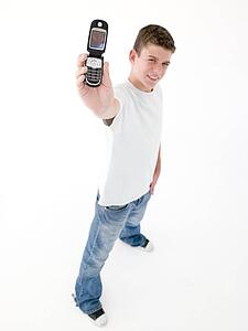 Teenage boy holding up cellular phone and smiling