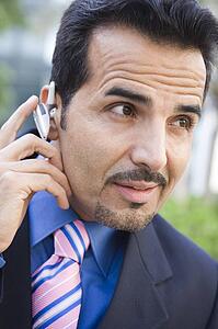 Businessman outdoors wearing headset (selective focus)