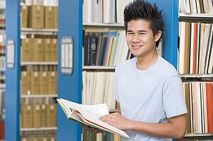 Man in library holding book (depth of field)