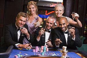 Five people in casino playing roulette and smiling (selective focus)