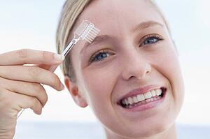 Woman with eyebrow brush smiling