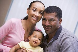 Couple indoors with baby smiling