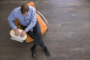 Businessman sitting indoors with laptop