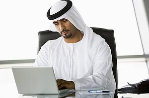 Businessman in office with laptop working (high key/selective focus)