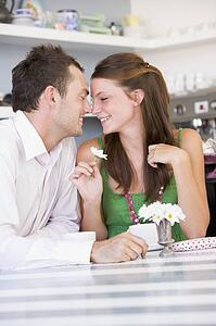 Young couple sitting at a table looking into each other's eyes