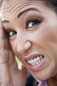 Woman's frustrated face outdoors (selective focus)
