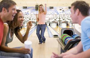 Woman bowling with friends