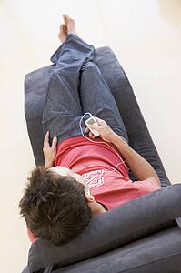 Man sitting in chair listening to MP3 player