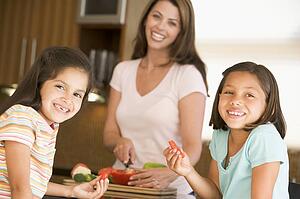 Girls Eating Pepper Strips While Mother Is Preparing meal, mealtime