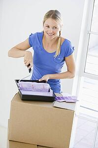 Woman painting room in new home smiling