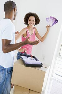 Couple with paint swatches in new home smiling