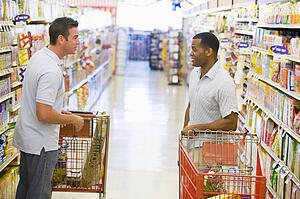 Two men talking to each other at a grocery store
