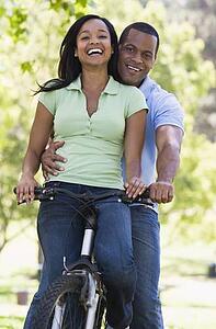 Couple on a bike outdoors smiling