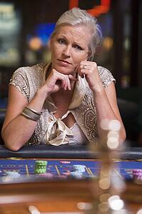Woman in casino playing roulette and thinking (selective focus)