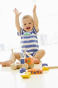 Baby indoors playing with truck
