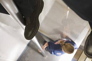 Shot of fireman's legs on a fire pole with firewoman at bottom (selective focus)