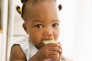 Young girl eating apple indoors