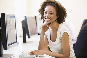 Woman wearing headset in computer room smiling