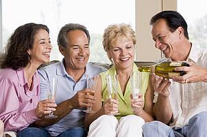 Two couples in living room drinking champagne and smiling