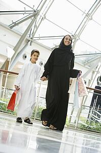 Woman and young boy walking in mall smiling (selective focus)