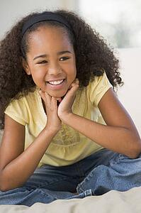 Young Girl Sitting On A Sofa At Home