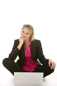 Businesswoman Sitting In Front Of Laptop Thinking