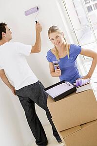 Couple painting room in new home smiling