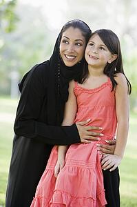 Woman and young girl outdoors in a park smiling (selective focus)