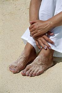 Woman's legs outdoors sitting at the beach