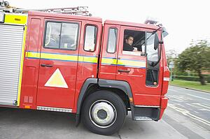 Firefighters driving fire engine out of driveway