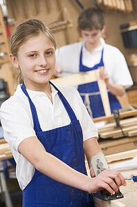 Female student learning woodworking