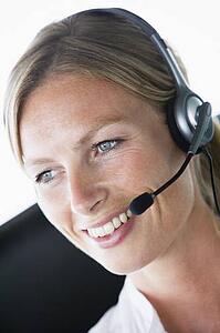 Businesswoman in office wearing headset and smiling