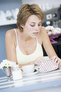 Young woman sitting at a table checking change purse