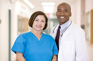 A Doctor And Nurse Standing In A Hospital Corridor