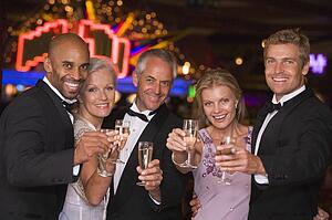 Five people in casino with champagne smiling (selective focus)