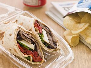 Steak, Cheese, Red Pepper And Barbeque Sauce Tortilla Wrap With A Can Of Cola And Packet Of Crisps