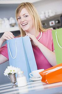 Young woman sitting at a table taking a break from shopping