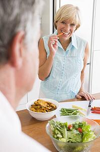 Woman Talking To Husband As She Prepares A meal, mealtime