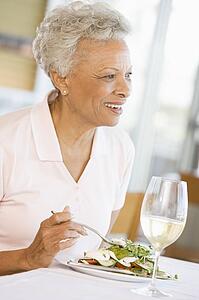 Woman Enjoying meal, mealtime With A Glass Of Wine