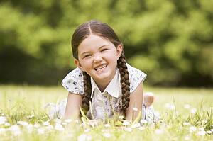 Young girl lying outdoors smiling